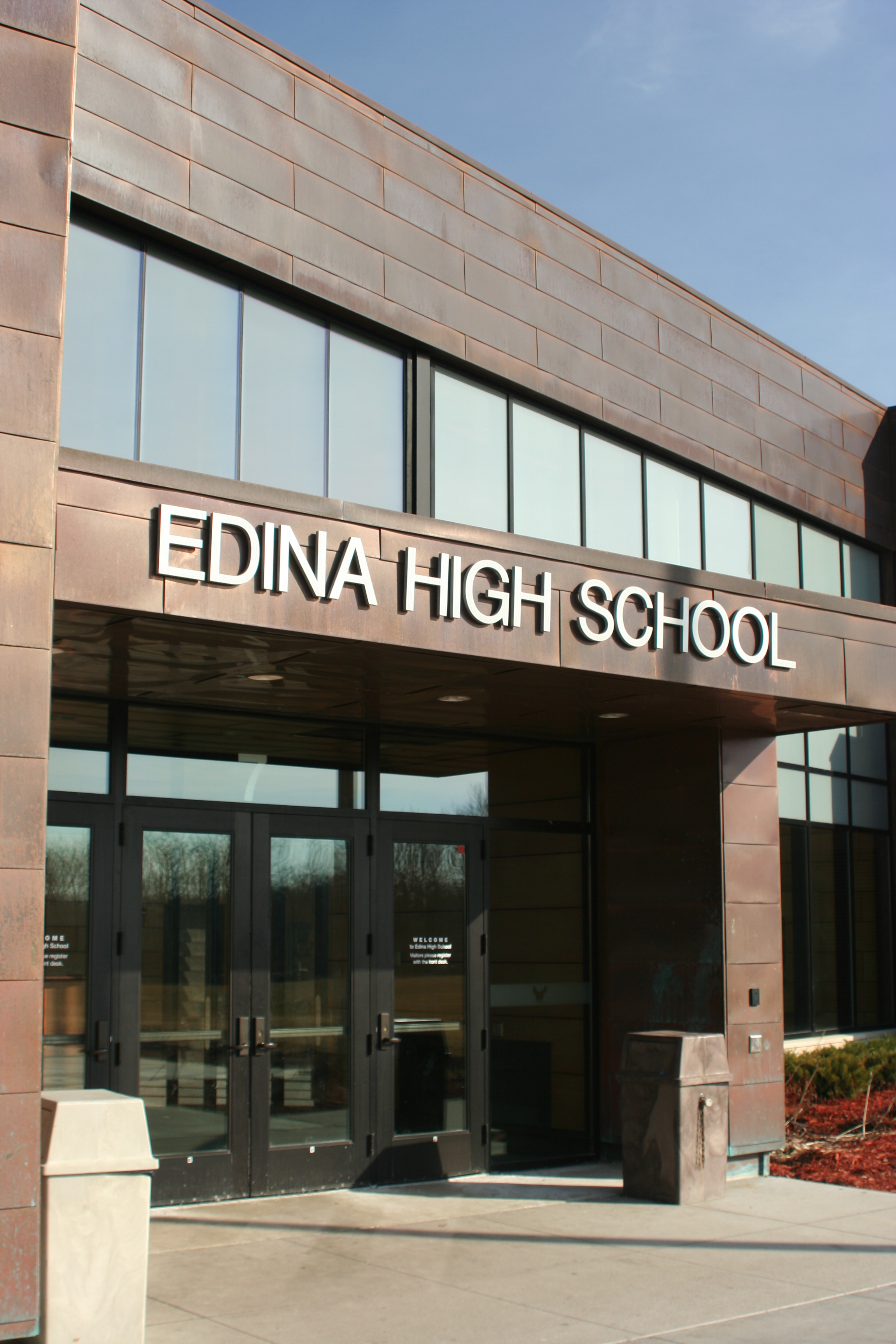 Exterior entrance and large Edina High School lettering above glass doors.